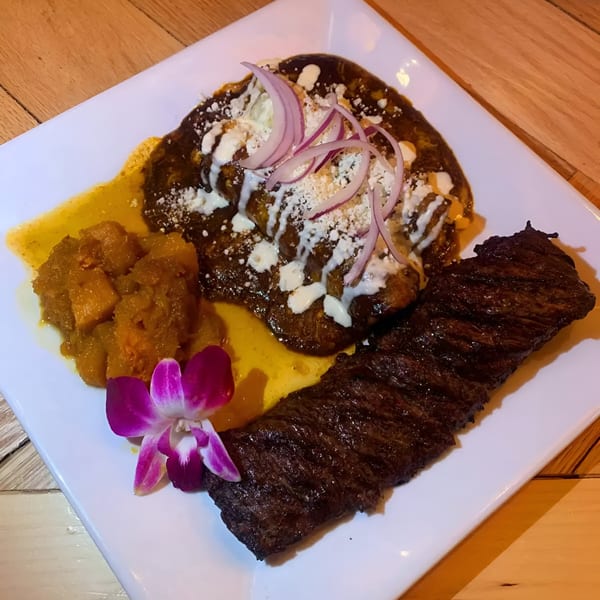 IXCHEL Mexican Cuisine's skirt steak with mole, plantains, and a purple orchid garnish.
